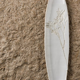 White ceramic Blanko tray with floral design on a brown textured surface