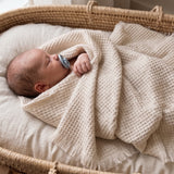 Baby with a beige 100% merino wool baby blanket 