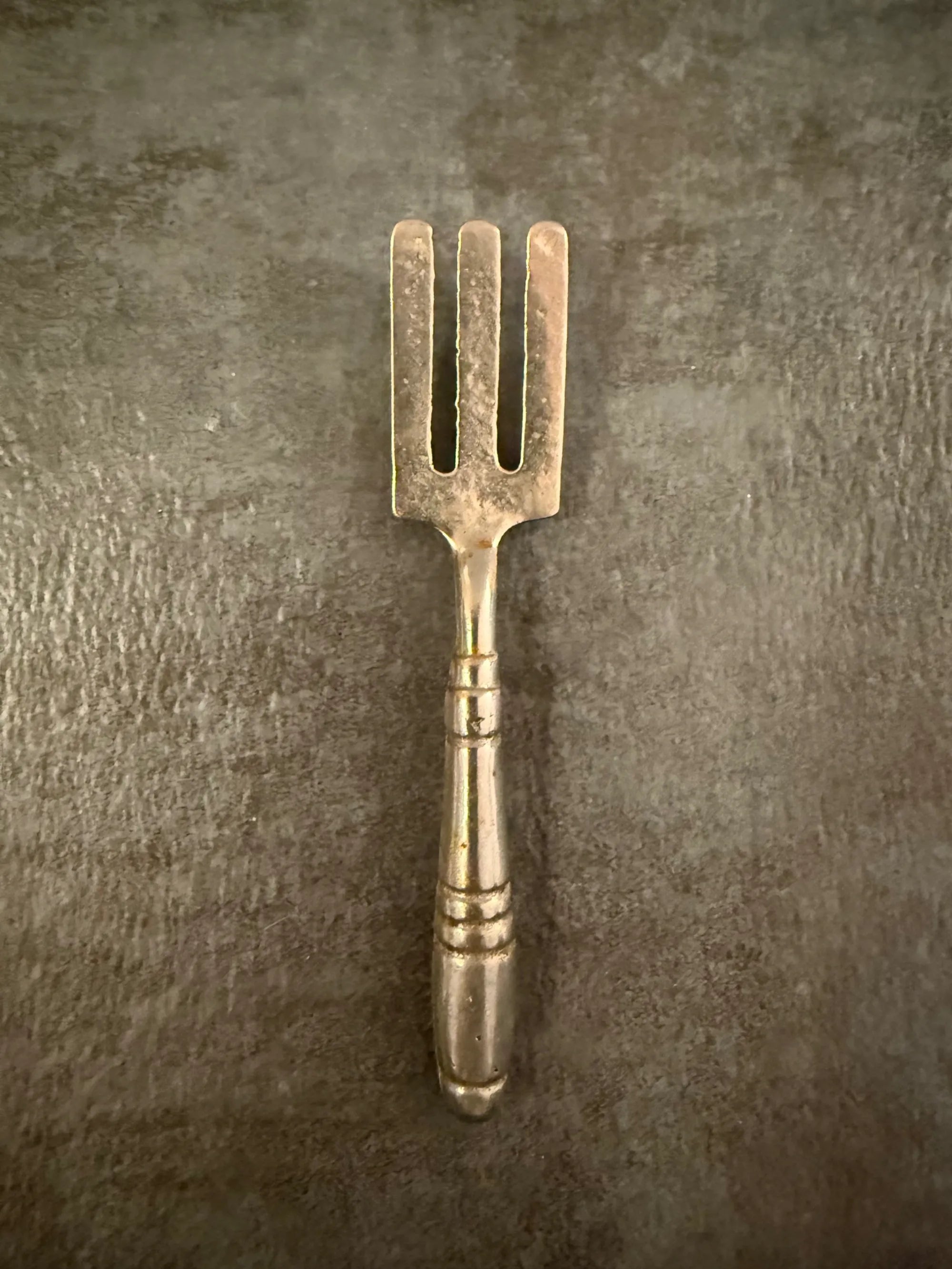 Vintage-style metal fork on a textured brown background