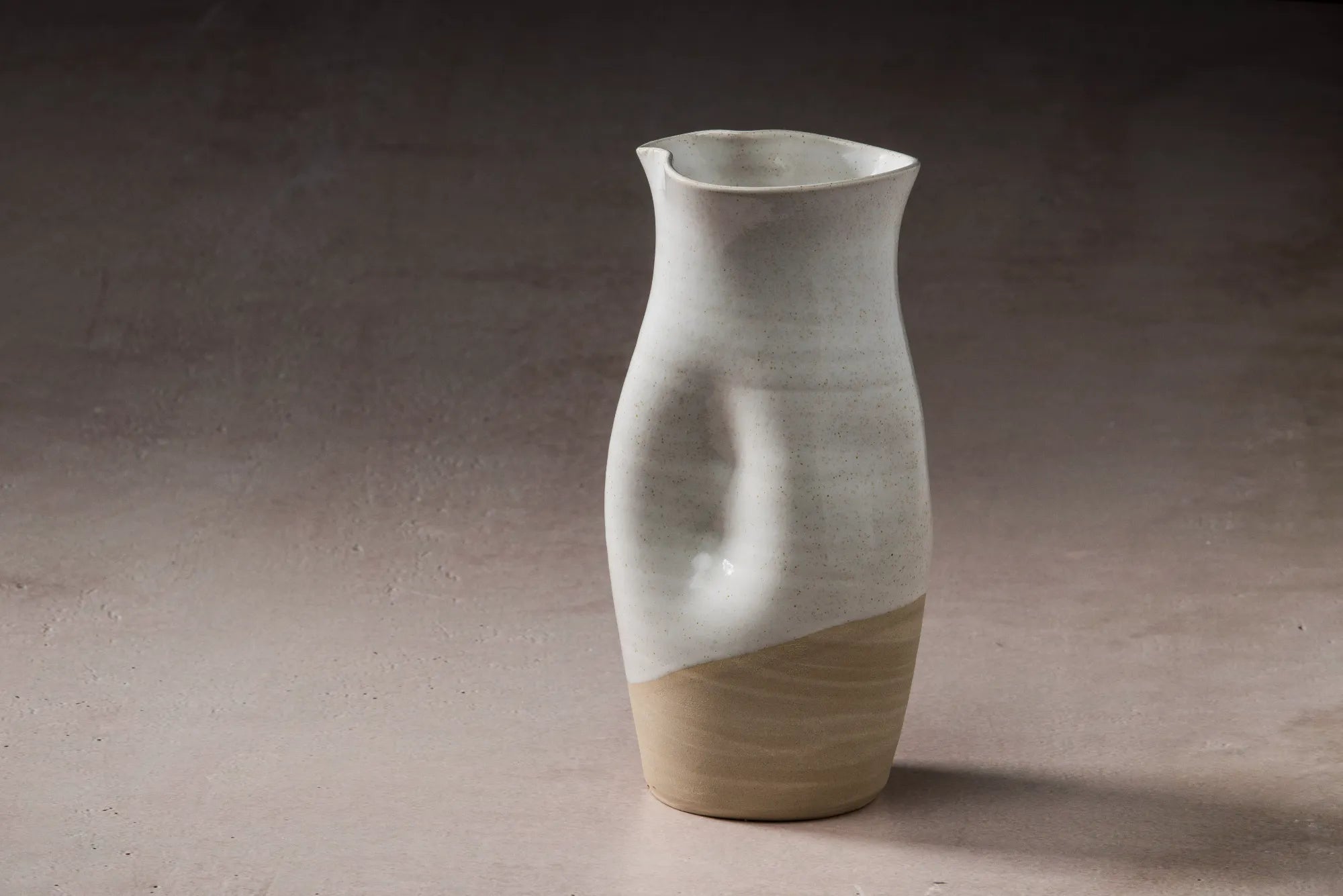 Ceramic JARRA pitcher with two-tone design on a neutral background