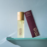 Rioja body oil bottle and box on a glass shelf against a light blue background