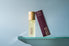 Rioja body oil bottle and box on a glass shelf against a light blue background