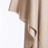 Beige 100% merino wool blanket draped over a white surface