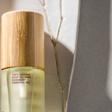 Bottle of natural body oil with a wooden cap on a light background