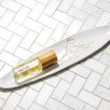 Rioja Holistic Home body oil product on a white dish with a tiled background