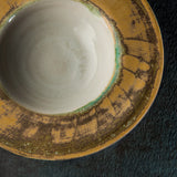 Ceramic Sombrero bowl with a textured yellow exterior on a dark background