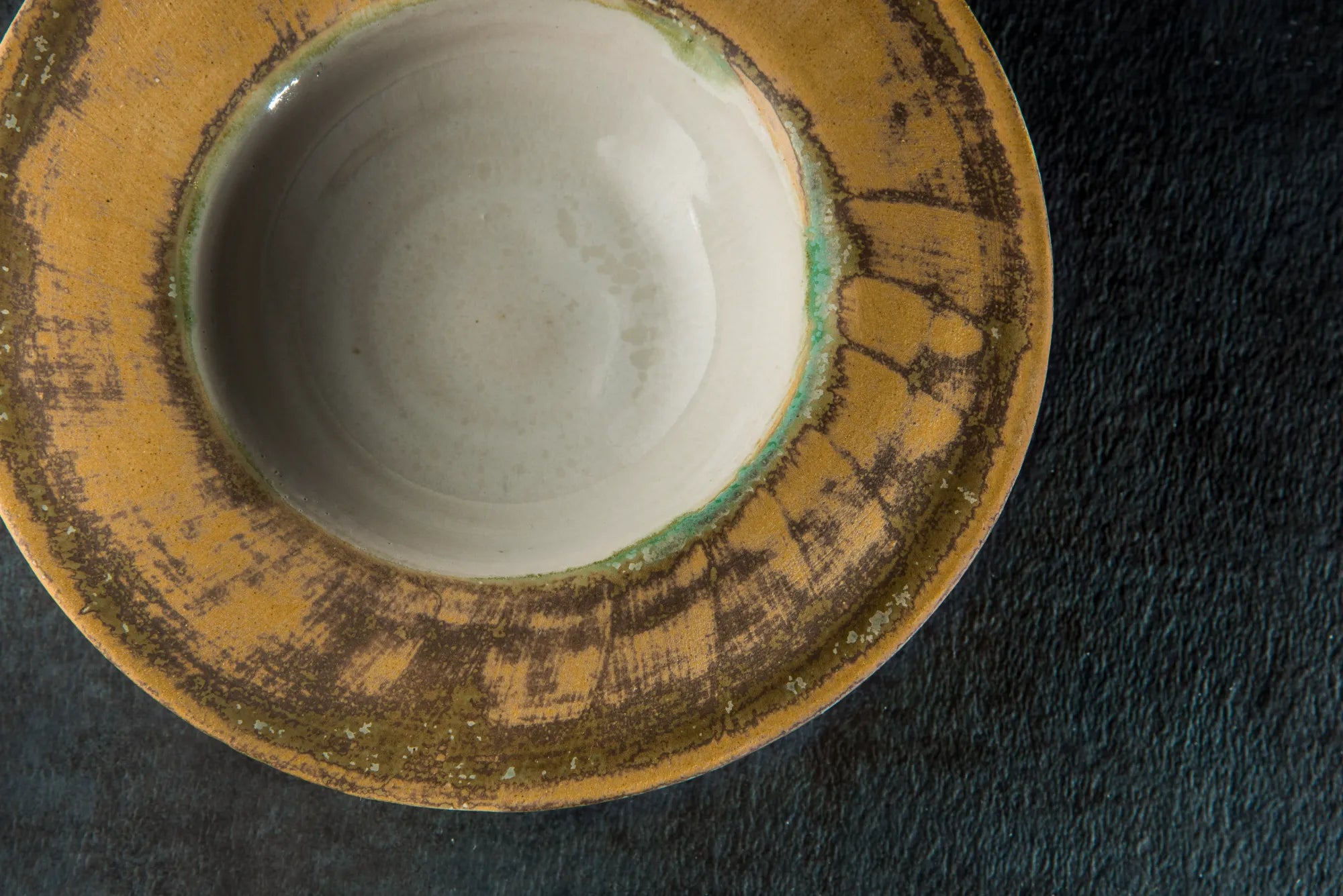 Ceramic Sombrero bowl with a textured yellow exterior on a dark background