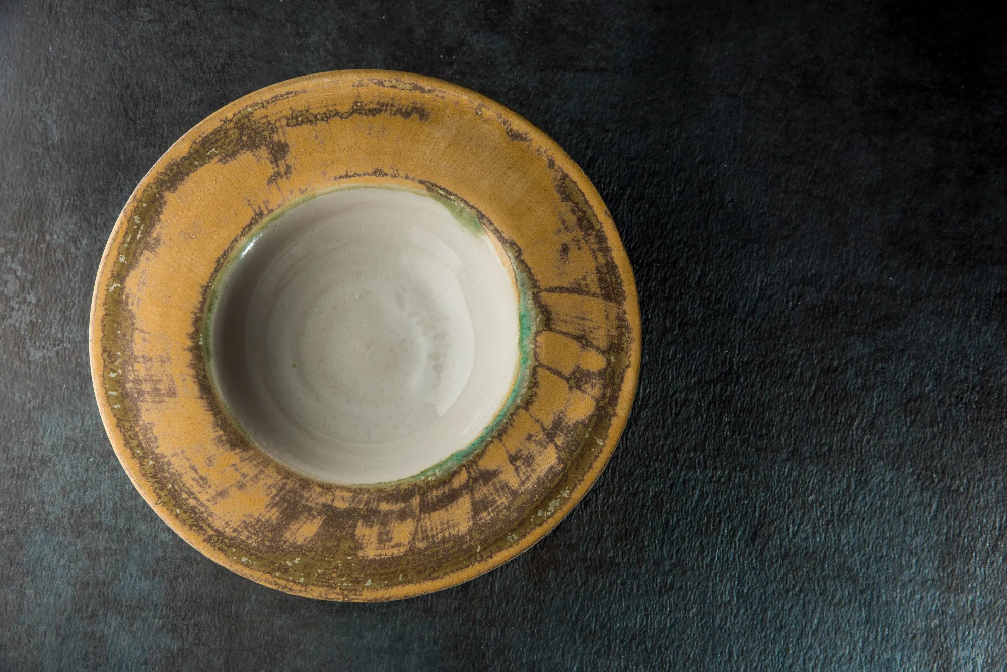 Ceramic Sombrero bowl with a textured yellow rim on a dark surface