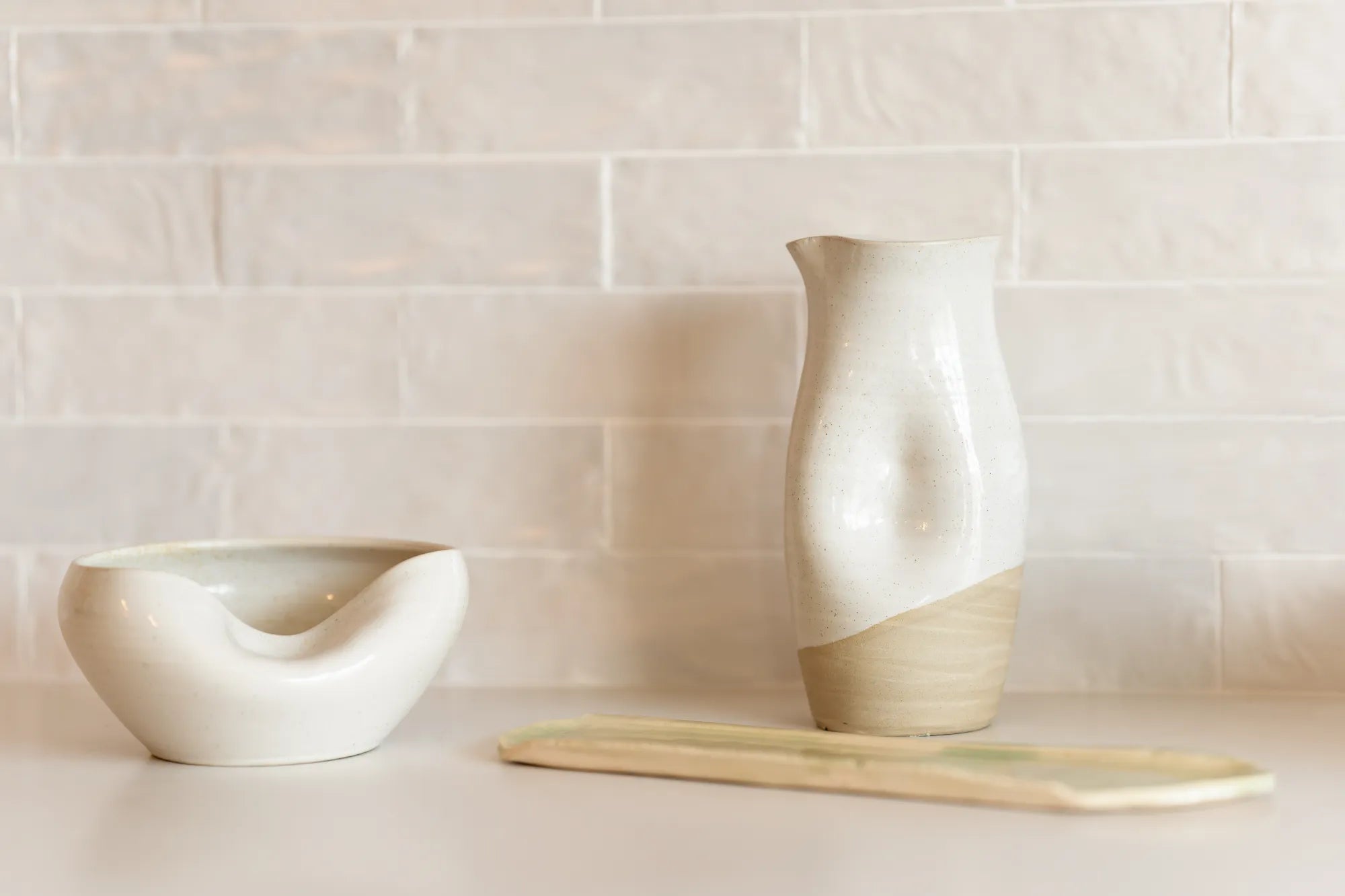 Cuenko bowl and Jarra pitcher on a white counter top next to the Verde tray by Rioja Holistic Home